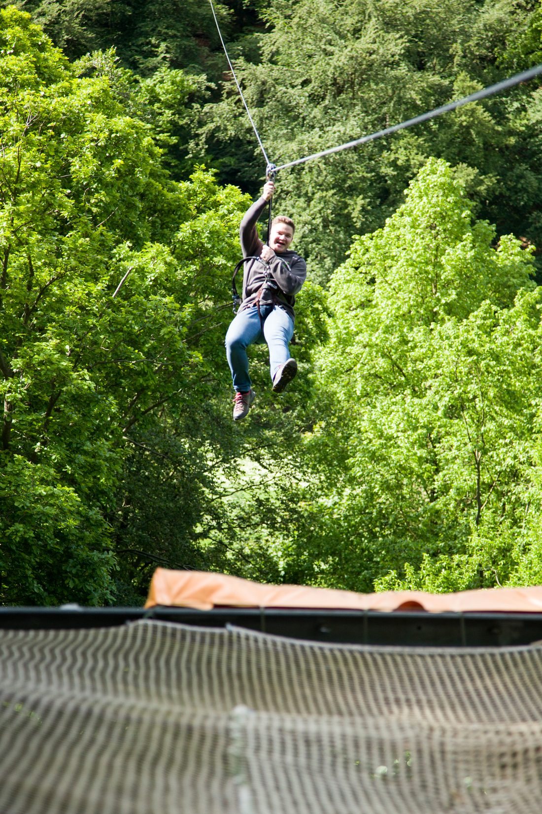 Person kommt an der Landeplattform der Megaseilbahn an, darunter das Fangnetz